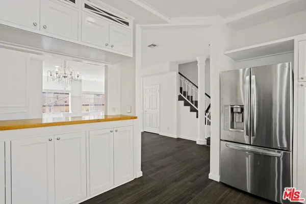 a kitchen with stainless steel appliances a refrigerator and a hard wood floor