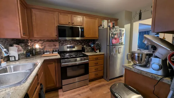a kitchen with stainless steel appliances granite countertop a sink stove and microwave