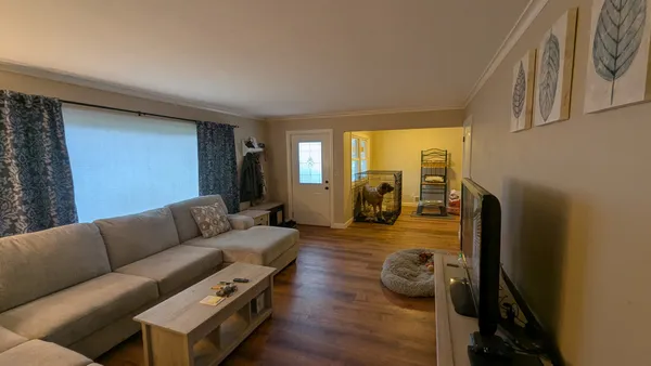 a living room with furniture and a wooden floor