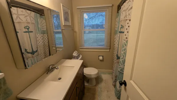 a bathroom with a sink a toilet and a mirror