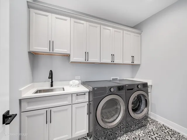 a utility room with sink dryer and washer