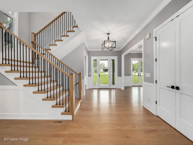 a view of a hallway with wooden floor and entryway