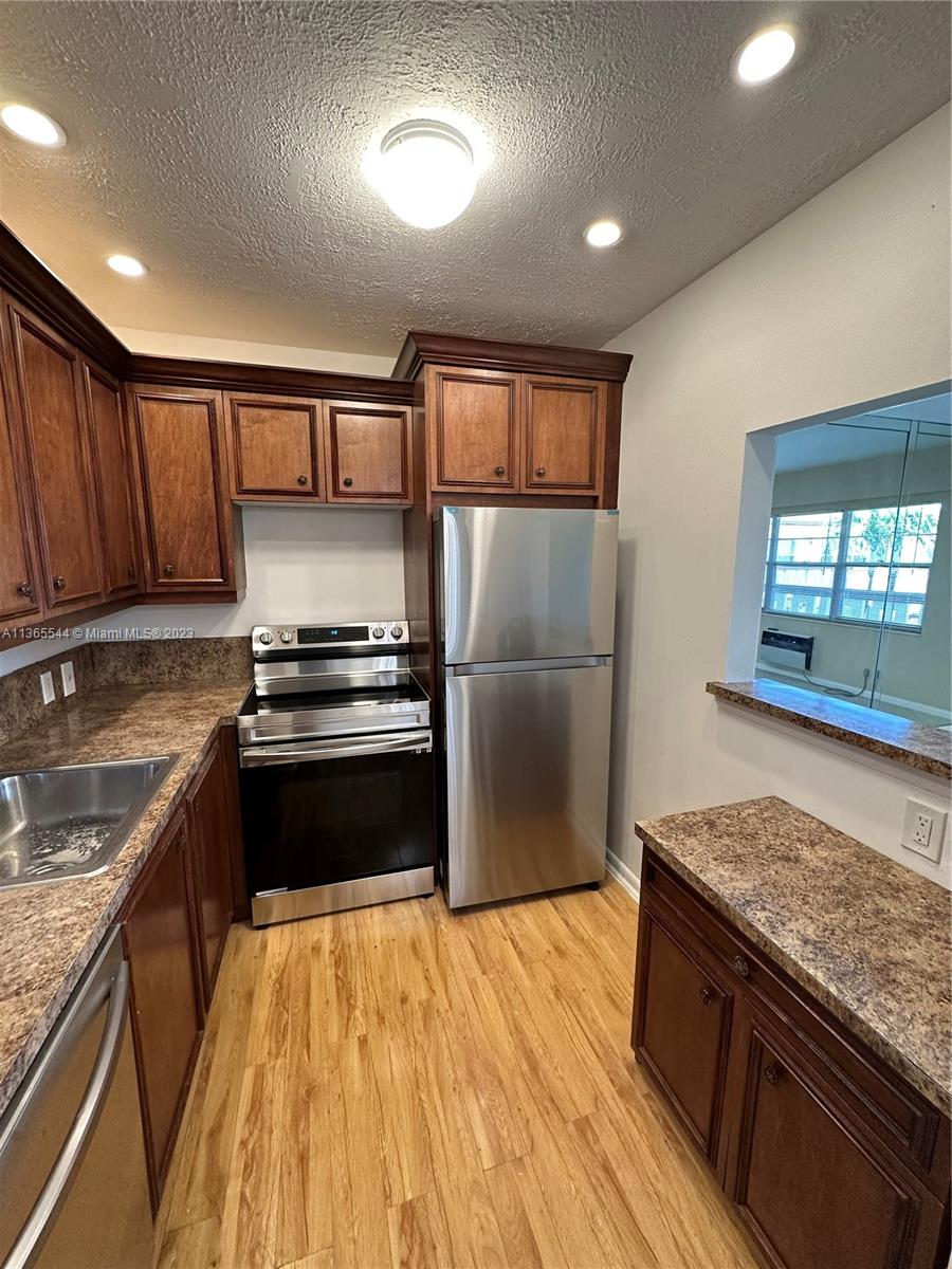 a kitchen with granite countertop stainless steel appliances and wooden cabinets