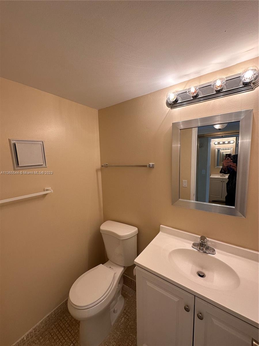 538 Mansfield M, Unit 538 Boca Raton, FL 33434 - Photo 7 of 13 a bathroom with a toilet sink and mirror