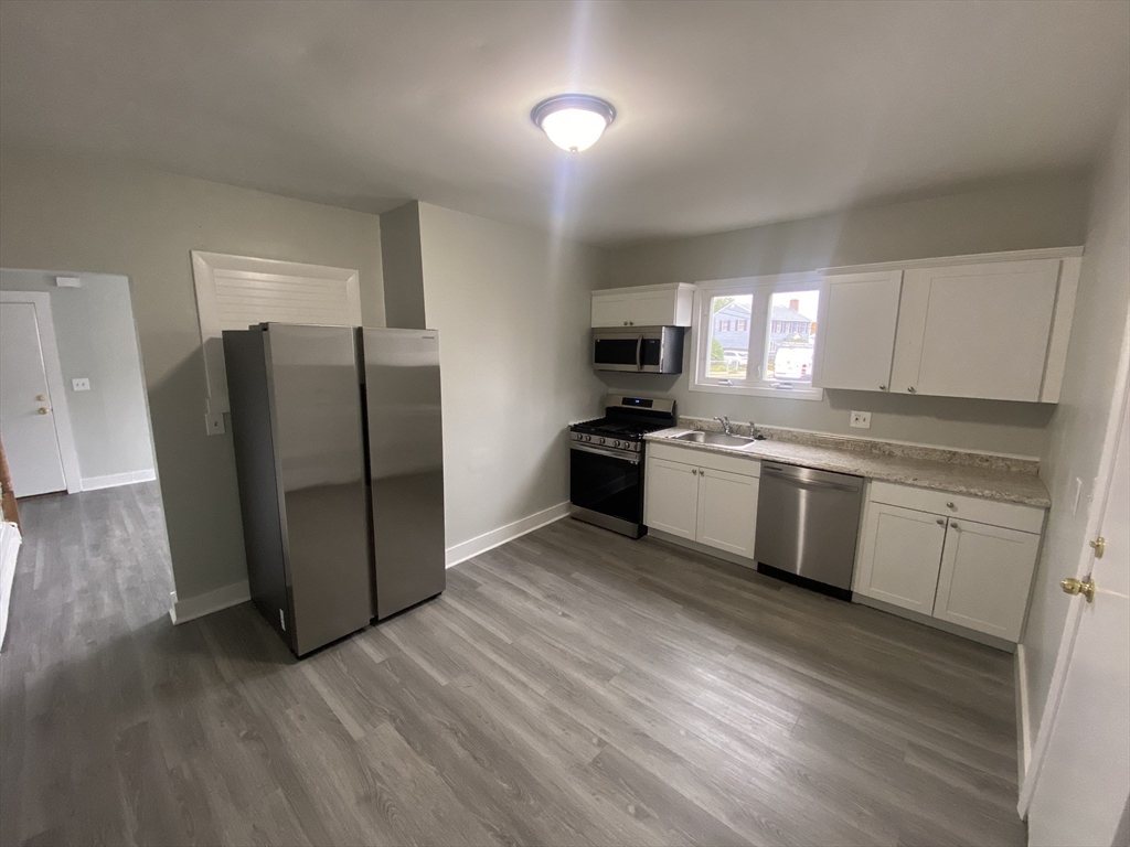 a kitchen with a refrigerator a sink and a stove top oven