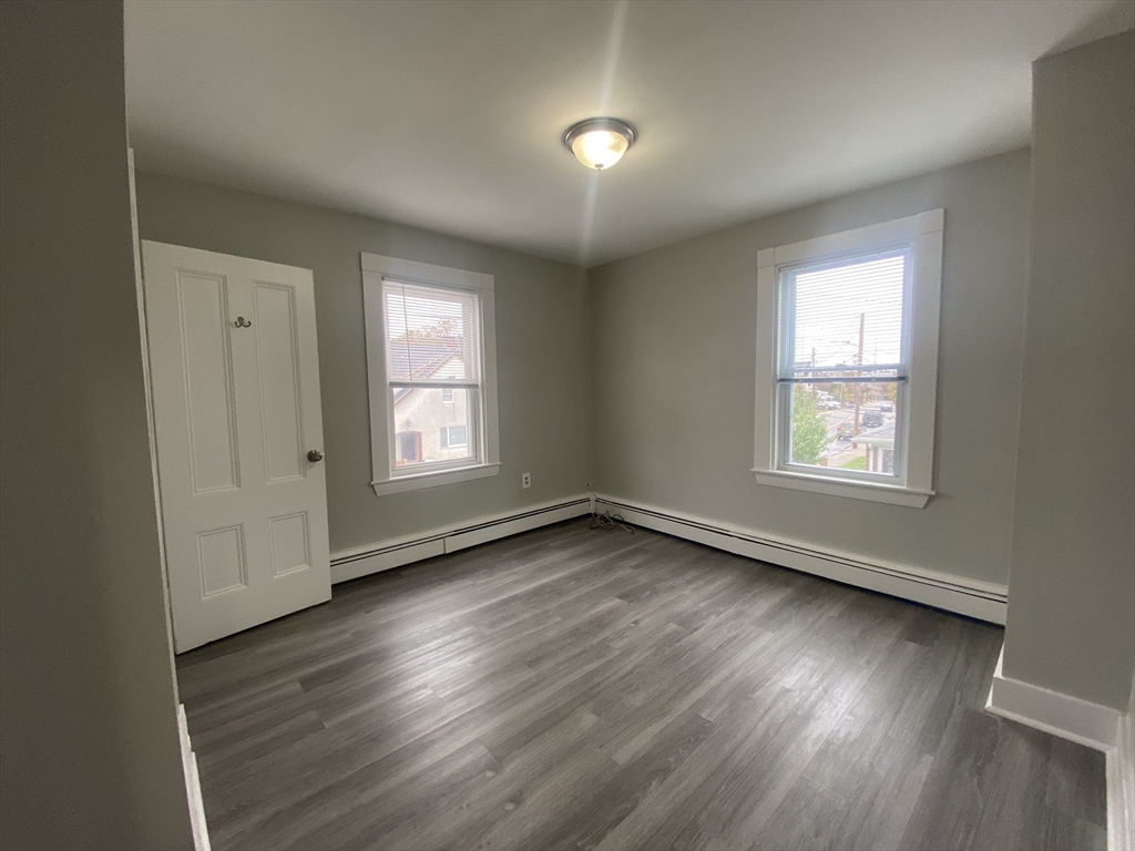 2 Swetts Court Watertown, MA 02472 - Photo 7 of 17 a view of an empty room with wooden floor and a window