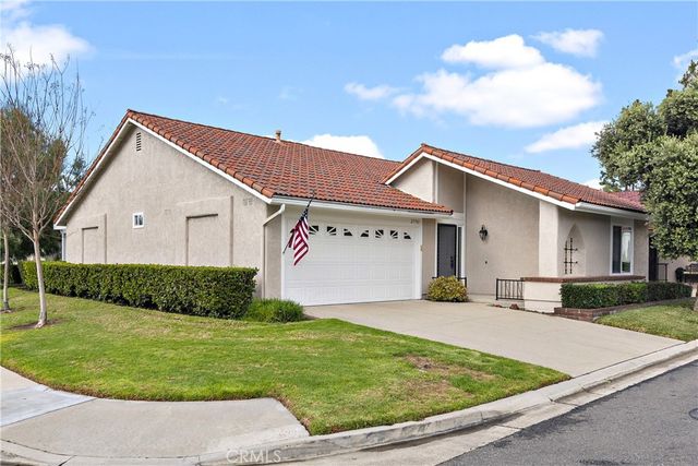 a view of a white house with a small yard and a large window