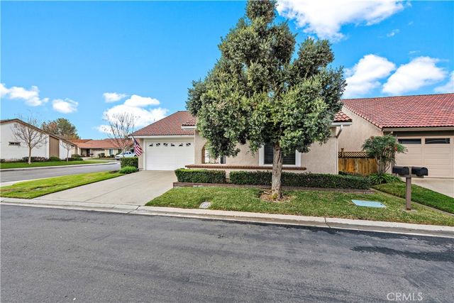 a view of a white house with a yard and large tree
