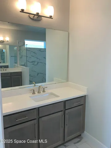 a bathroom with a sink vanity and a mirror