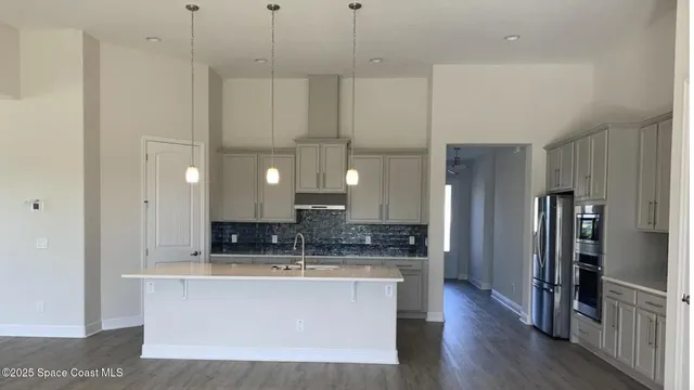 a large kitchen with kitchen island a sink stainless steel appliances and cabinets