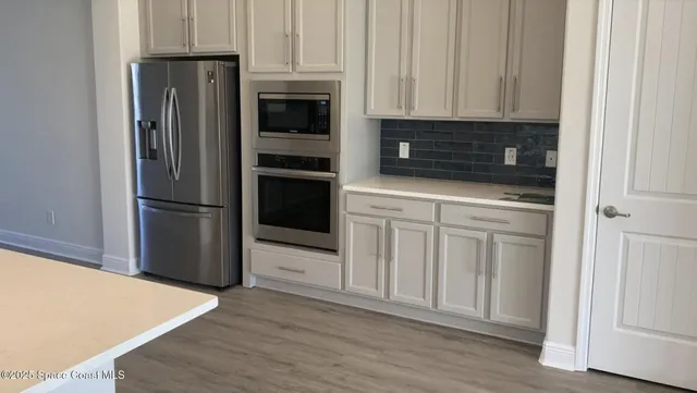 a kitchen with white cabinets and stainless steel appliances