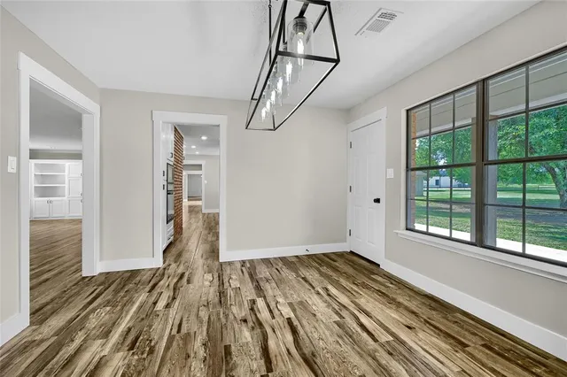 a view of empty room with wooden floor and windows