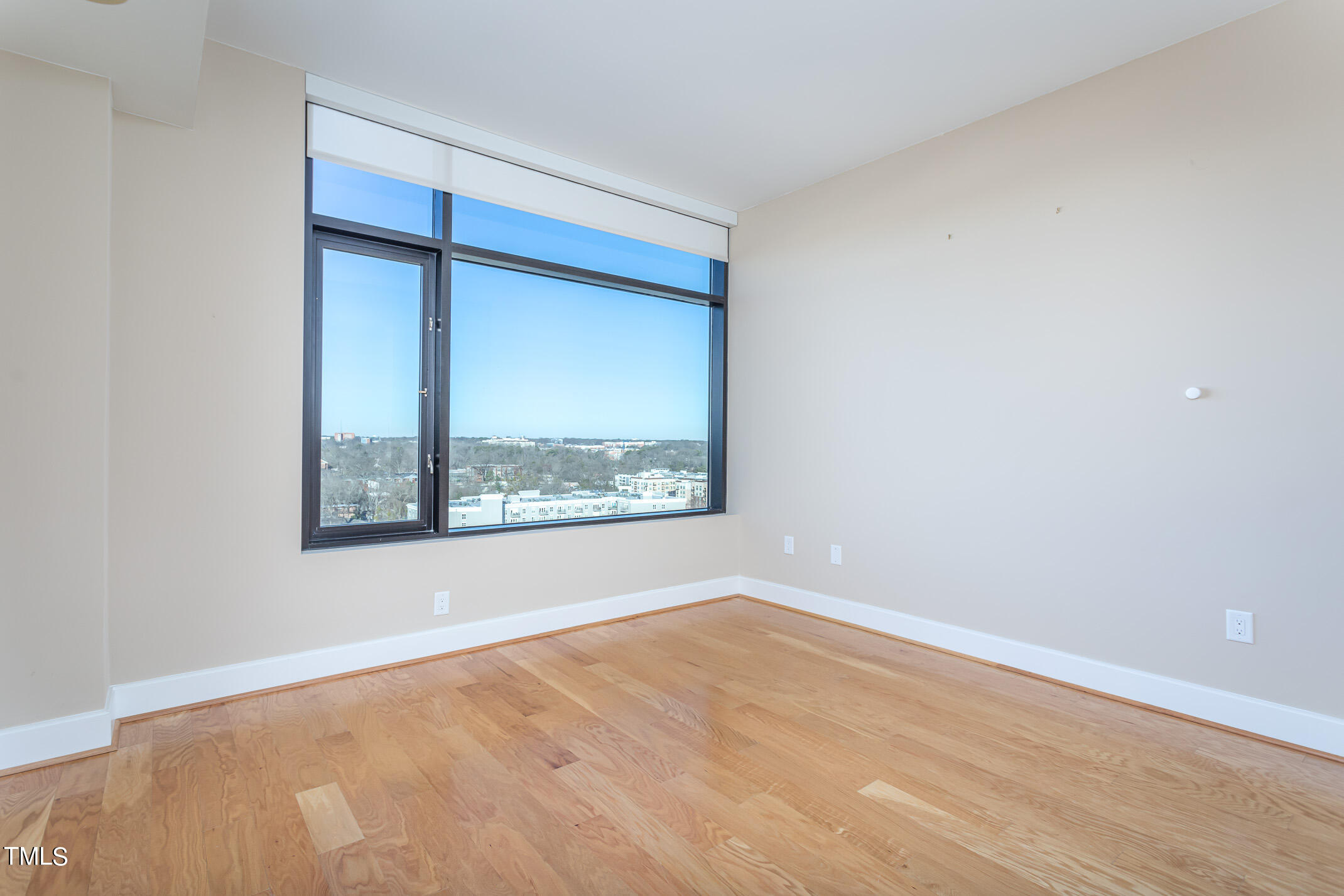 122 North Harrington Street, Unit 1075 Raleigh, NC 27603 - Photo 23 of 38 a view of an empty room with wooden floor and a window