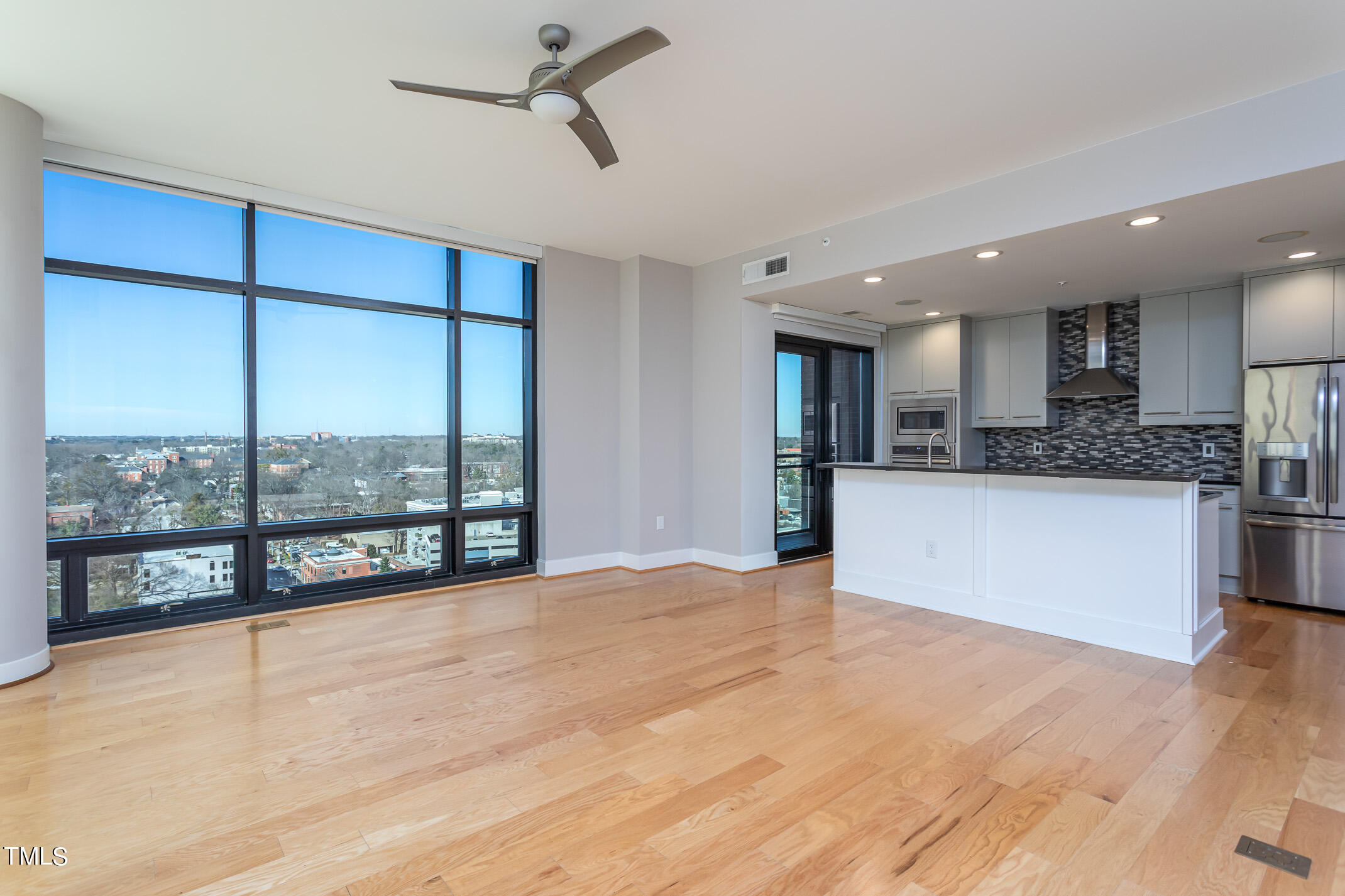 122 North Harrington Street, Unit 1075 Raleigh, NC 27603 - Photo 24 of 38 a view of a kitchen with kitchen island a large counter top space a large window and stainless steel appliances