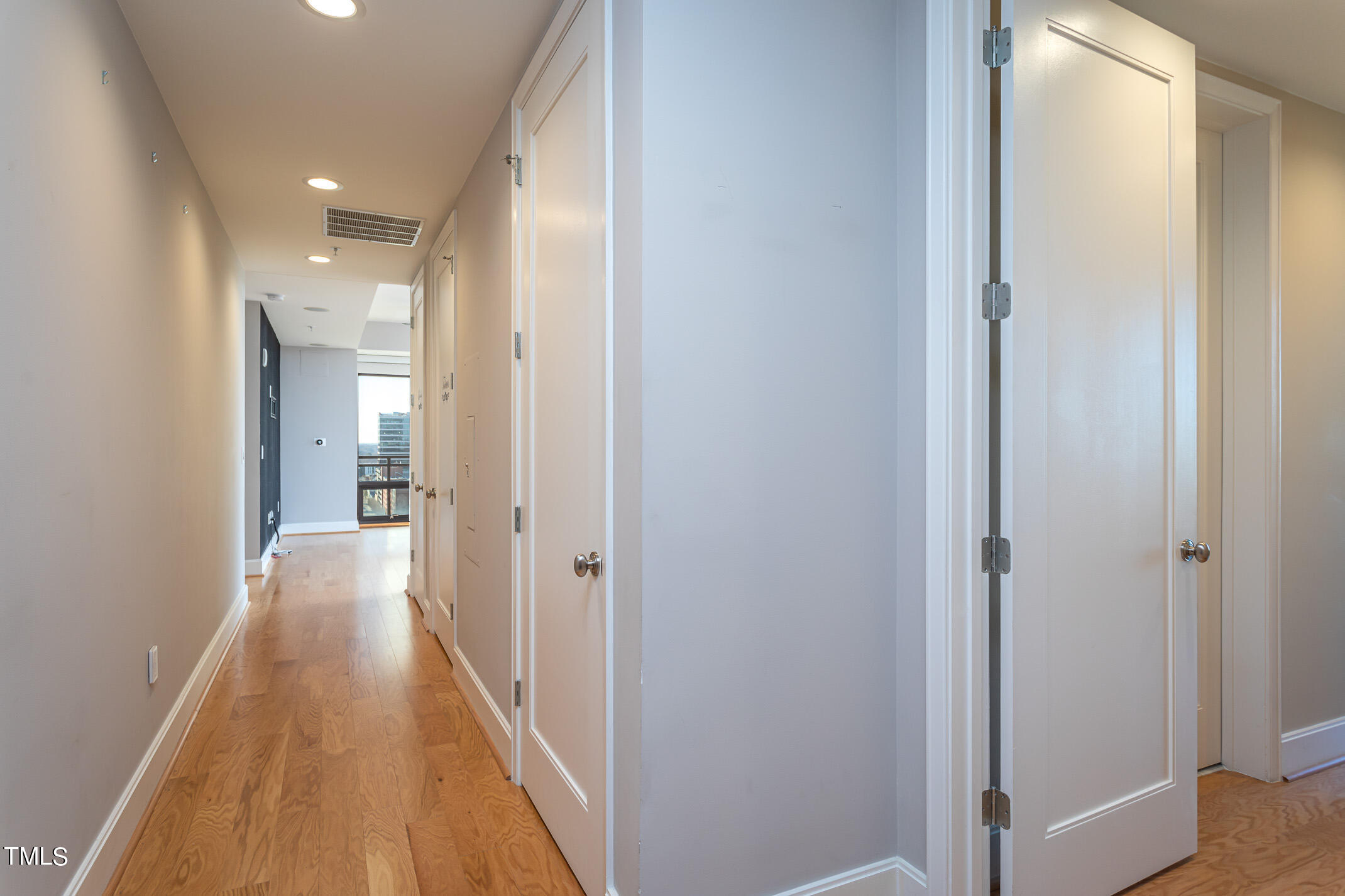122 North Harrington Street, Unit 1075 Raleigh, NC 27603 - Photo 28 of 38 a view of a hallway with wooden floor and a bathroom