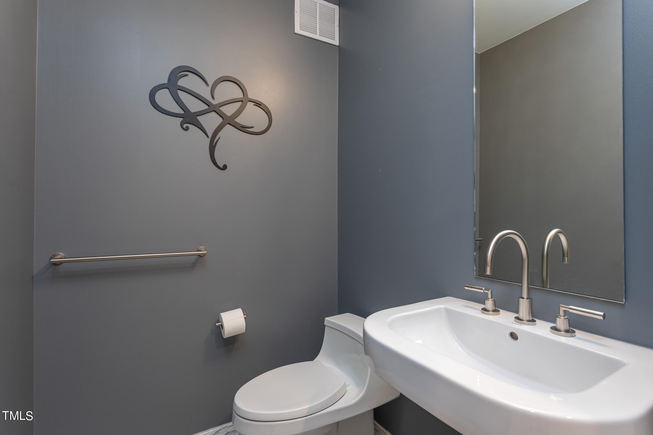 122 North Harrington Street, Unit 1075 Raleigh, NC 27603 - Photo 29 of 38 a bathroom with a sink a mirror and toilet