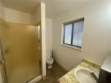a bathroom with a granite countertop toilet and sink