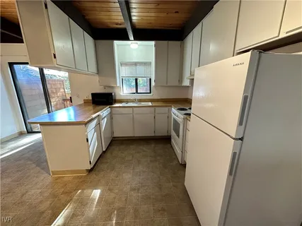 a kitchen with sink cabinets and white appliances