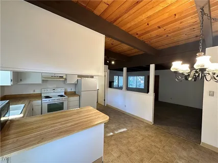 a kitchen with kitchen island a counter top a stove and a refrigerator