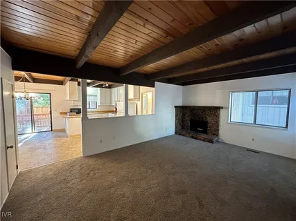 a view of an empty room with a fireplace and a window