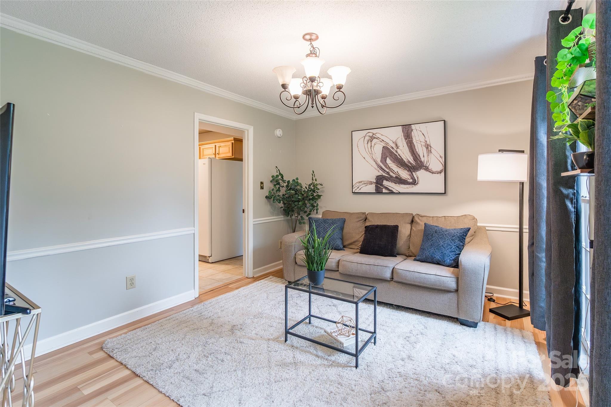 6816 Porterfield Road Charlotte, NC 28226 - Photo 13 of 31 a living room with furniture and a chandelier