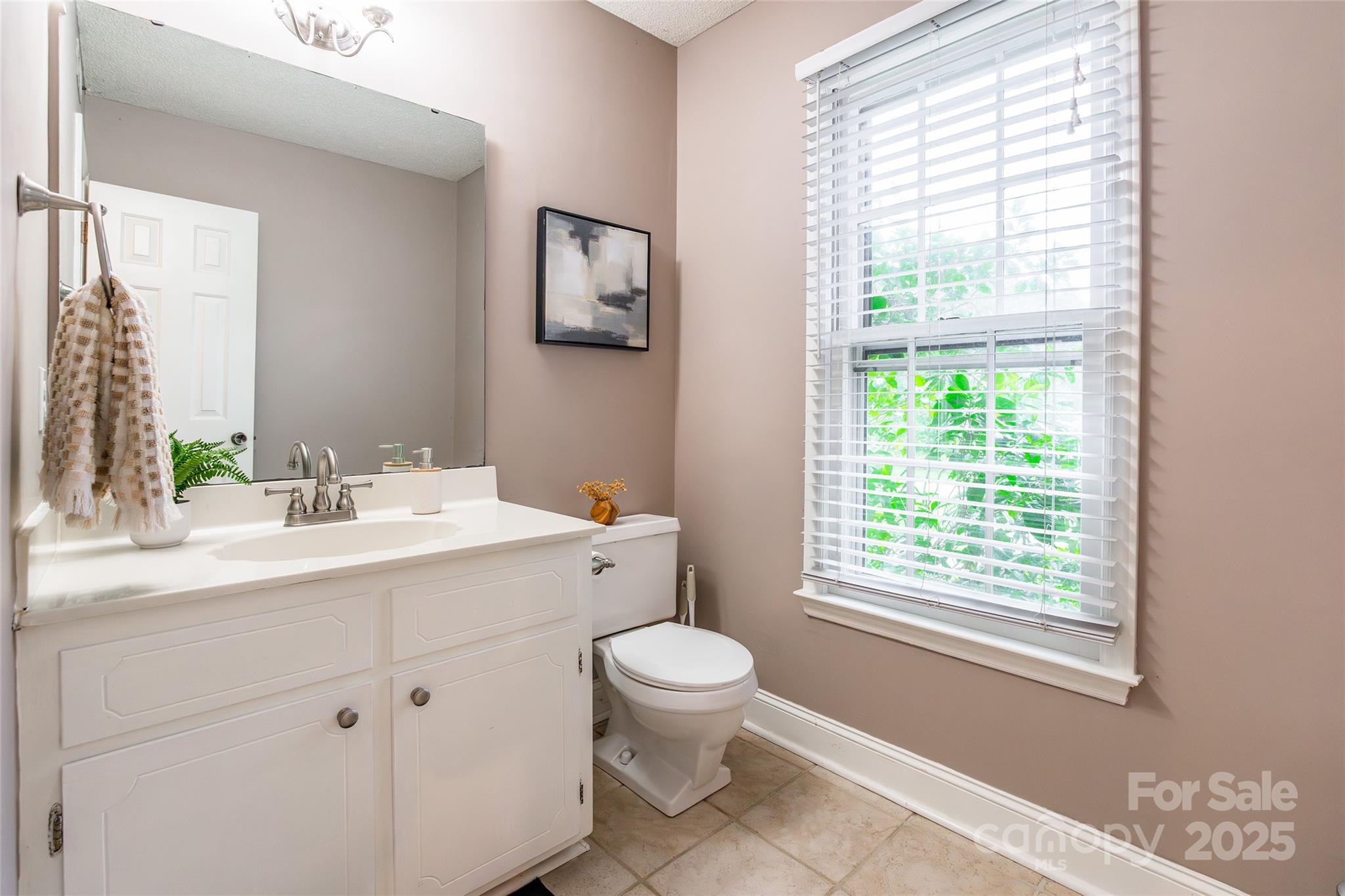6816 Porterfield Road Charlotte, NC 28226 - Photo 14 of 31 a bathroom with a granite countertop sink toilet a large mirror next to a window