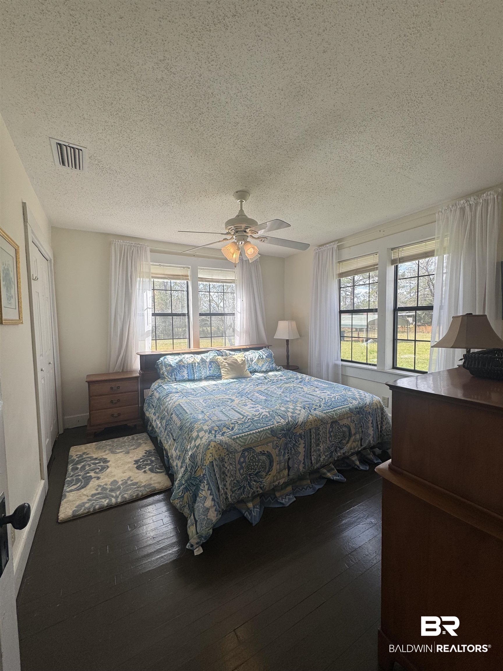275 Thames Road Frisco City, AL 36445 - Photo 15 of 24 Bedroom with baseboards, visible vents, ceiling fan, hardwood / wood-style floors, and a textured ceiling