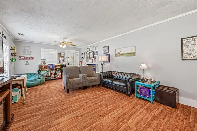 a living room with furniture and a wooden floor