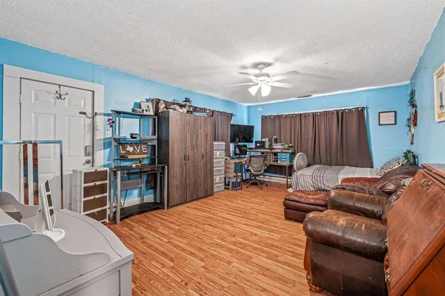 a living room with furniture a refrigerator and a dresser
