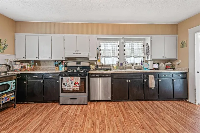 a kitchen with stainless steel appliances granite countertop a stove a sink dishwasher and a refrigerator