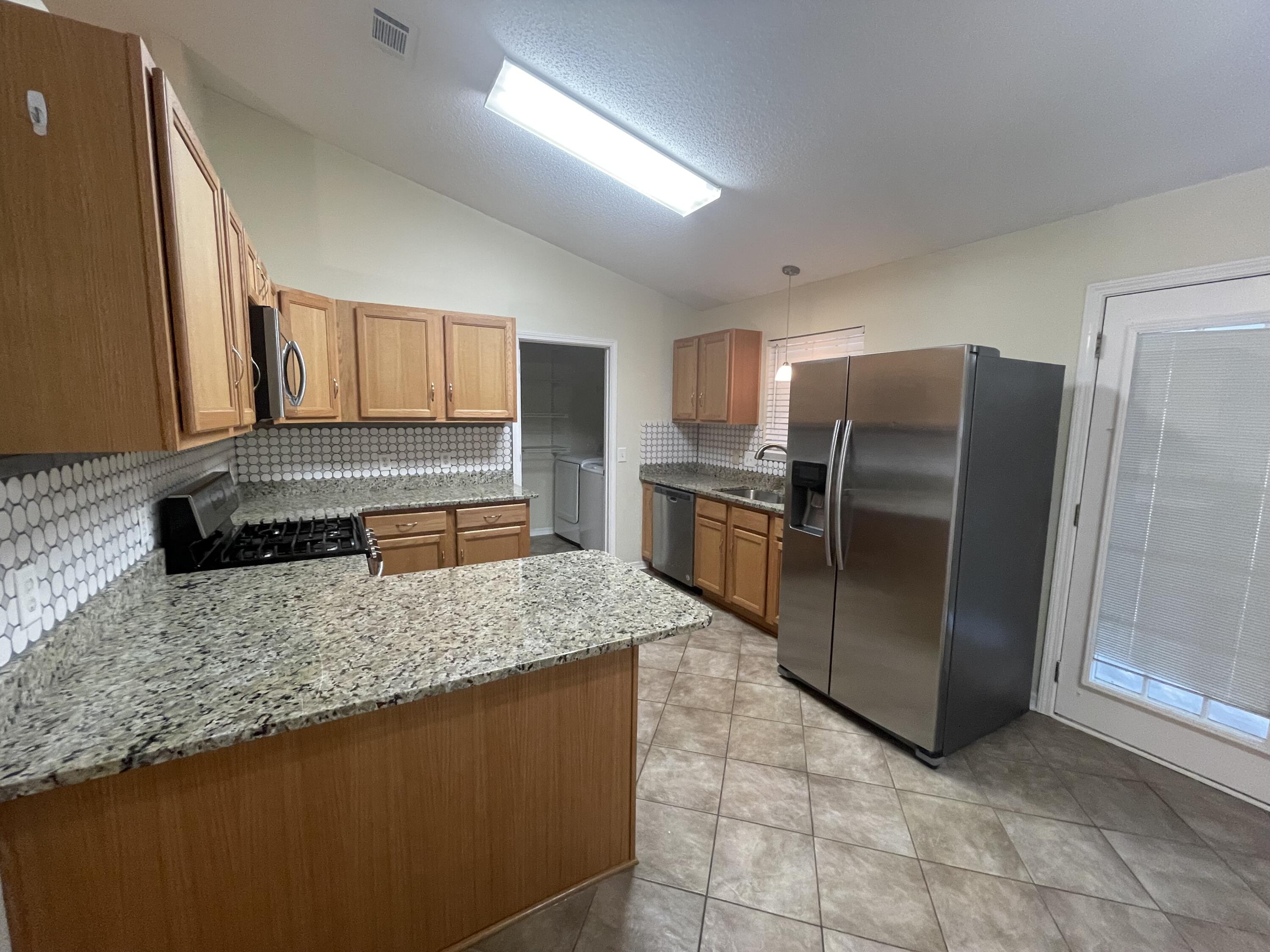 105 Steeplechase Drive Crestview, FL 32539 - Photo 3 of 14 a kitchen with stainless steel appliances granite countertop a refrigerator and a sink