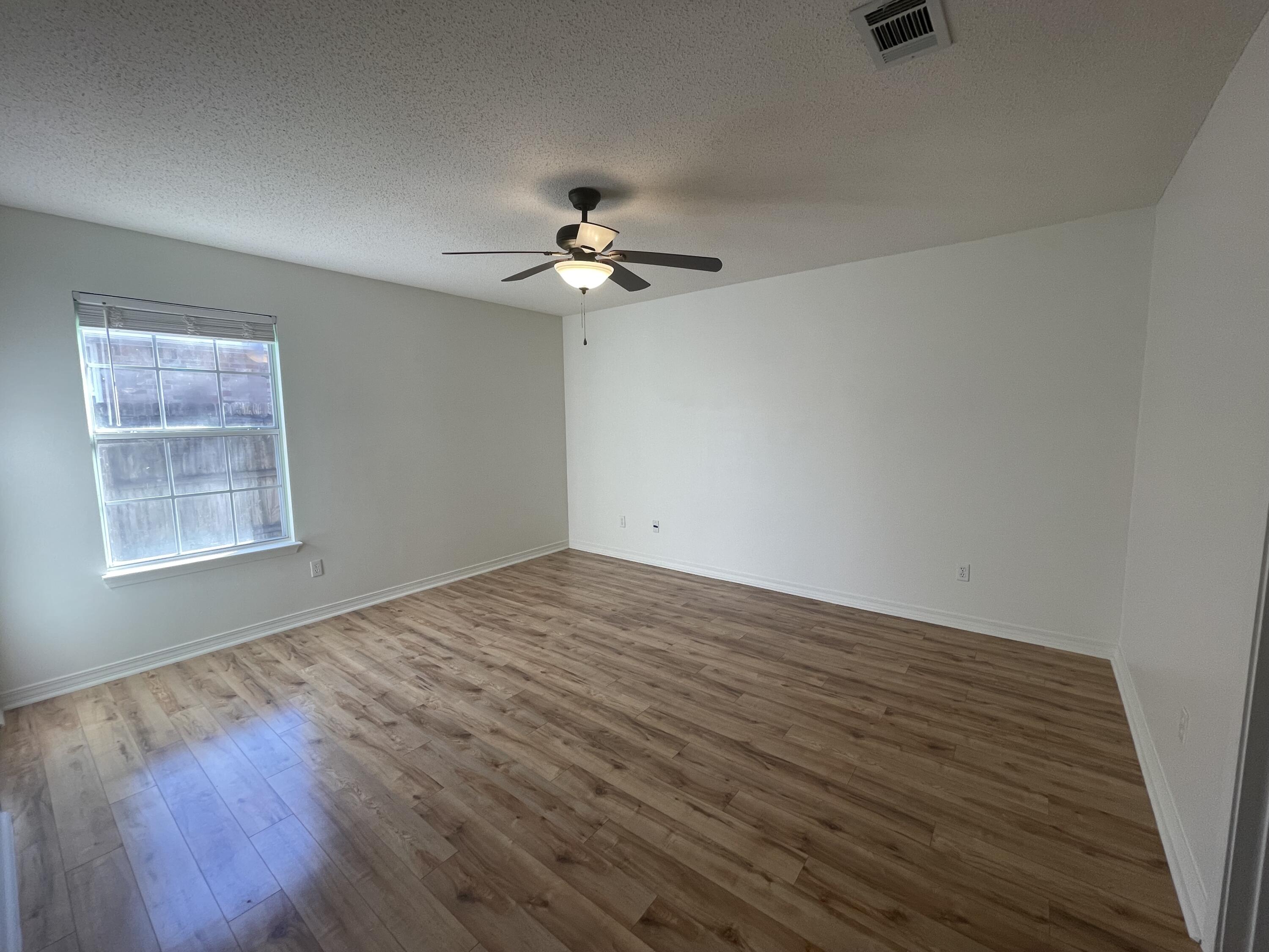 105 Steeplechase Drive Crestview, FL 32539 - Photo 7 of 14 wooden floor in an empty room with a window