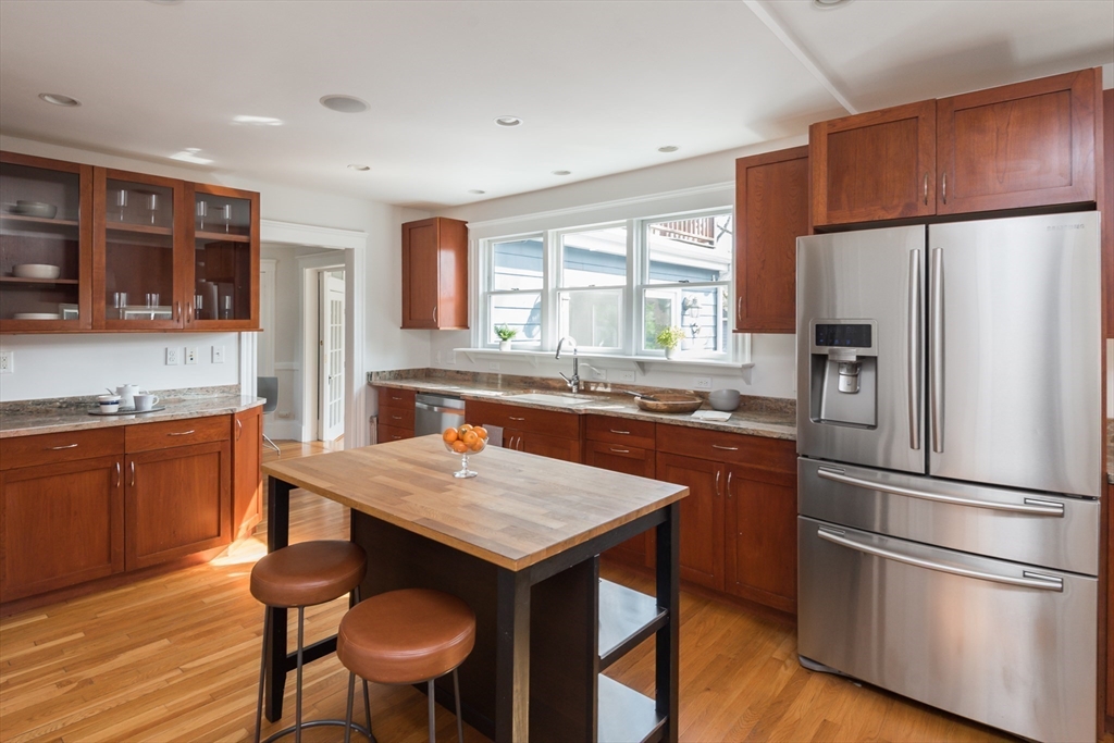 33 Ottawa Road Arlington, MA 02476 - Photo 14 of 38 a kitchen with stainless steel appliances granite countertop a refrigerator a sink a stove a dining table and chairs