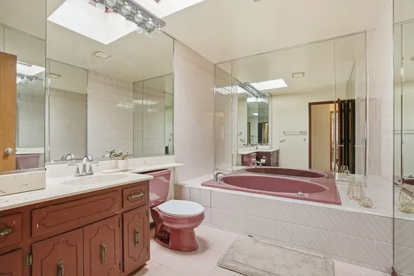 a spacious bathroom with a sink a toilet a mirror and shower