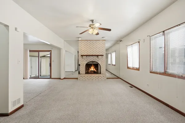 an empty room with a ceiling fan and window