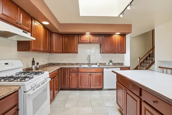a kitchen with a sink stove top oven and cabinets