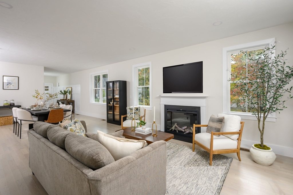 20 Howland Trail, Unit 35 Hanson, MA 02341 - Photo 20 of 26 a living room with furniture a fireplace and a flat screen tv