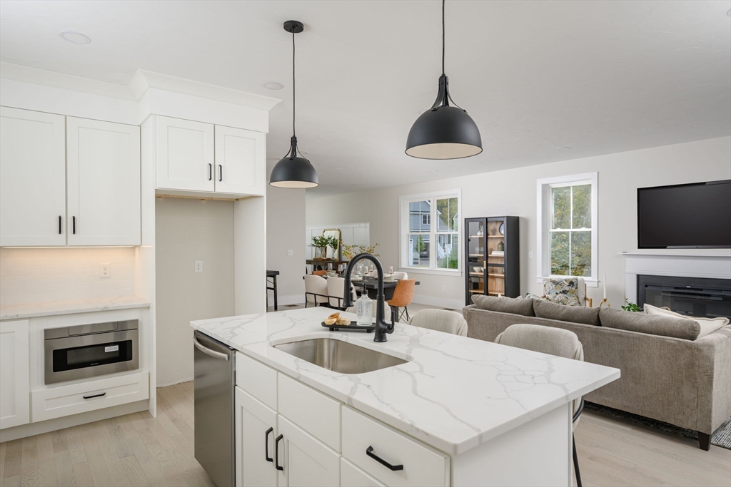 20 Howland Trail, Unit 35 Hanson, MA 02341 - Photo 2 of 26 a kitchen with stainless steel appliances granite countertop a sink a microwave and a refrigerator