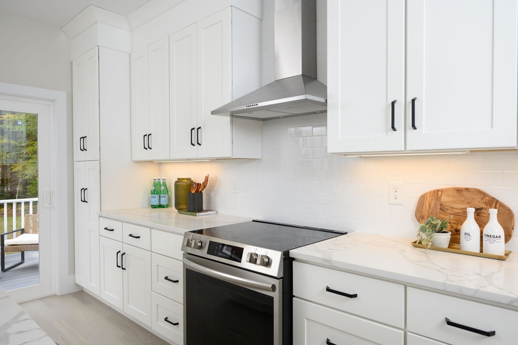 20 Howland Trail, Unit 35 Hanson, MA 02341 - Photo 25 of 26 a kitchen with white cabinets and a stove