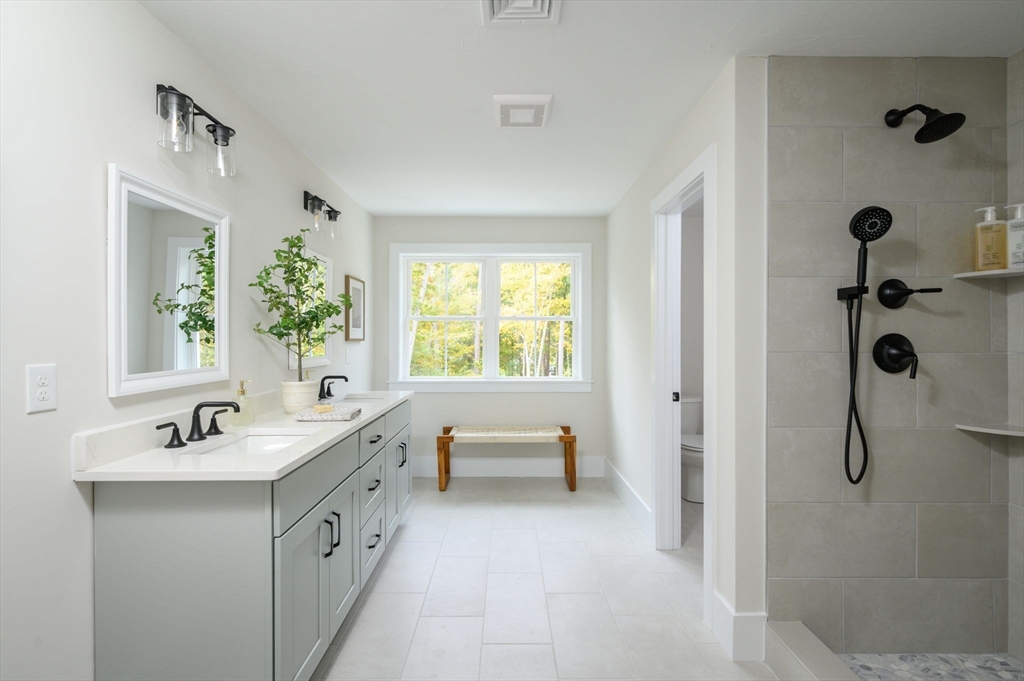 20 Howland Trail, Unit 35 Hanson, MA 02341 - Photo 8 of 26 a spacious bathroom with a double vanity sink a mirror and a bathtub