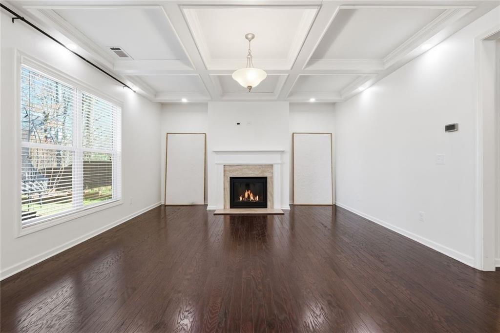 2495 Matlin Way Buford, GA 30519 - Photo 12 of 36 a view of an empty room with wooden floor fireplace and a window