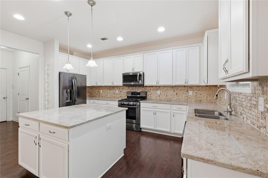 2495 Matlin Way Buford, GA 30519 - Photo 13 of 36 a kitchen with granite countertop white cabinets and stainless steel appliances