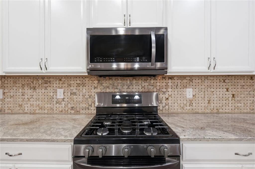 2495 Matlin Way Buford, GA 30519 - Photo 16 of 36 a kitchen with granite countertop a stove and a microwave