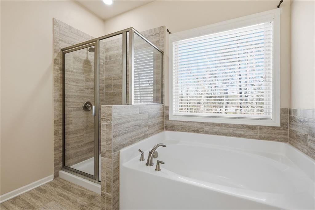 2495 Matlin Way Buford, GA 30519 - Photo 24 of 36 a bathroom with bathtub next to a window