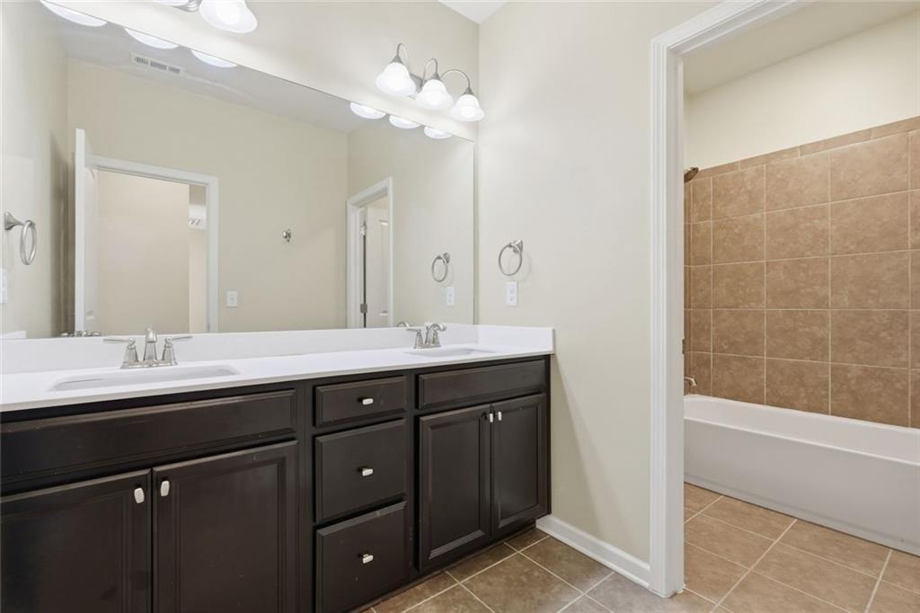 2495 Matlin Way Buford, GA 30519 - Photo 31 of 36 a bathroom with a double vanity sink and a mirror