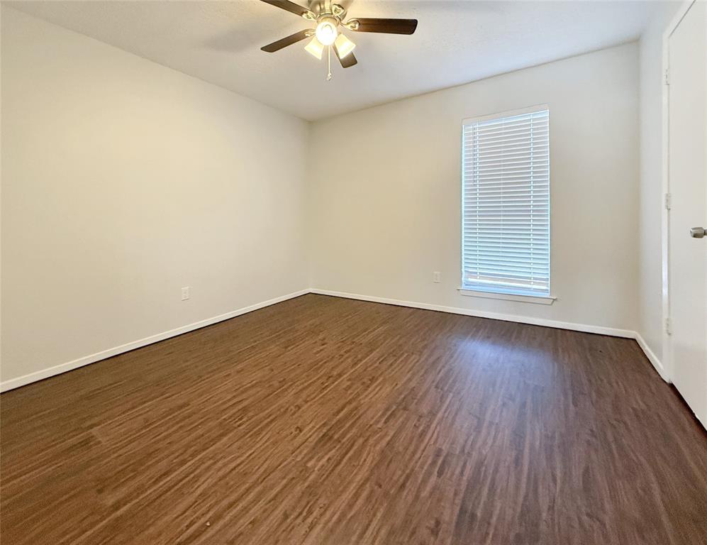 425 Southwest Thomas Street, Unit B Burleson, TX 76028 - Photo 13 of 22 an empty room with wooden floor and windows