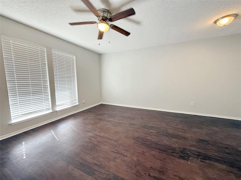 425 Southwest Thomas Street, Unit B Burleson, TX 76028 - Photo 7 of 22 an empty room with wooden floor and windows