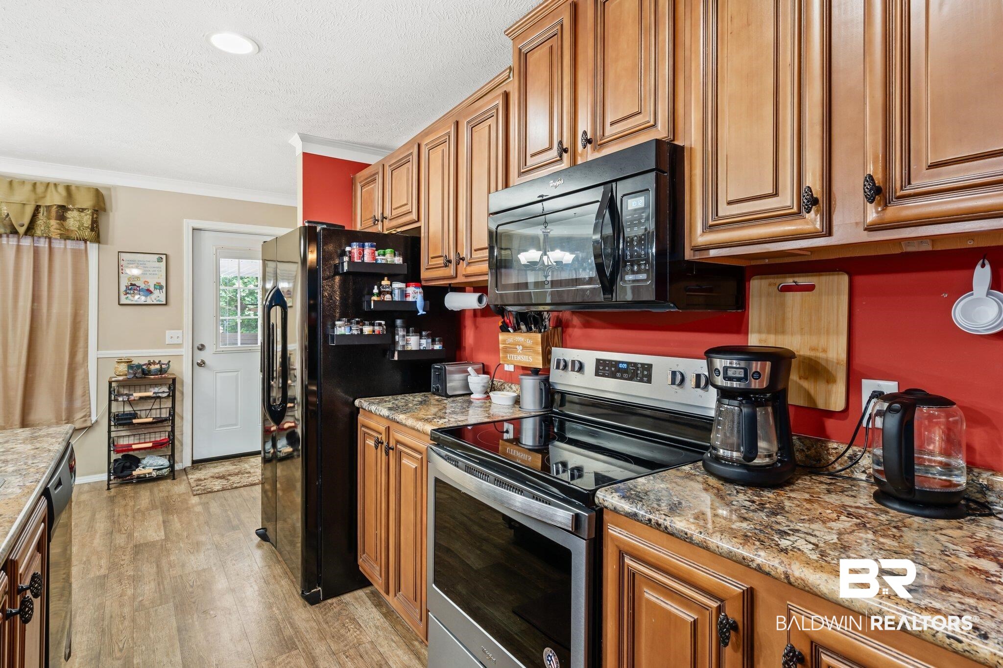 4510 Brannon Road Wilmer, AL 36587 - Photo 6 of 36 Kitchen with light wood-type flooring, ornamental molding, light stone counters, and black appliances