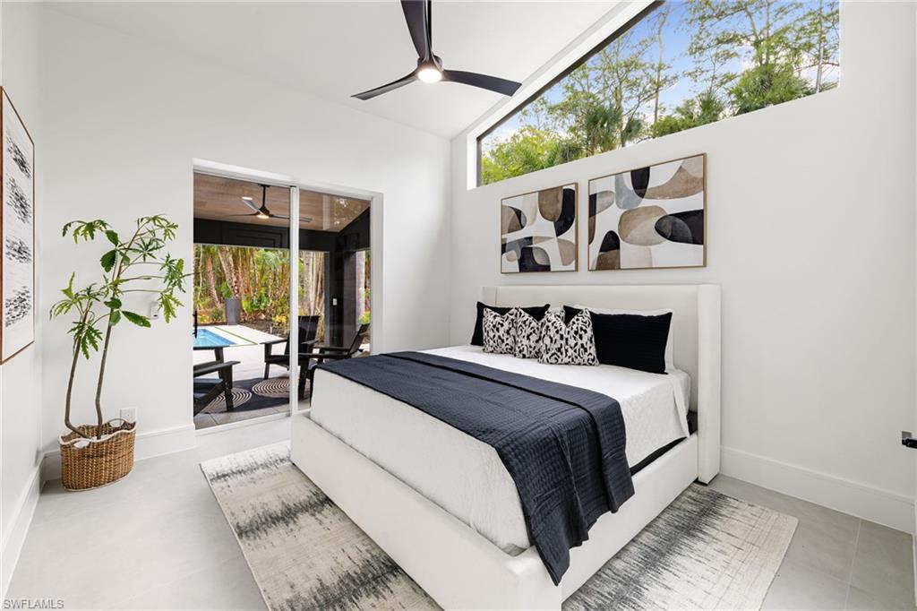 4521 3rd Avenue Northwest Naples, FL 34119 - Photo 21 of 46 a spacious bedroom with a bed a couch and a potted plant