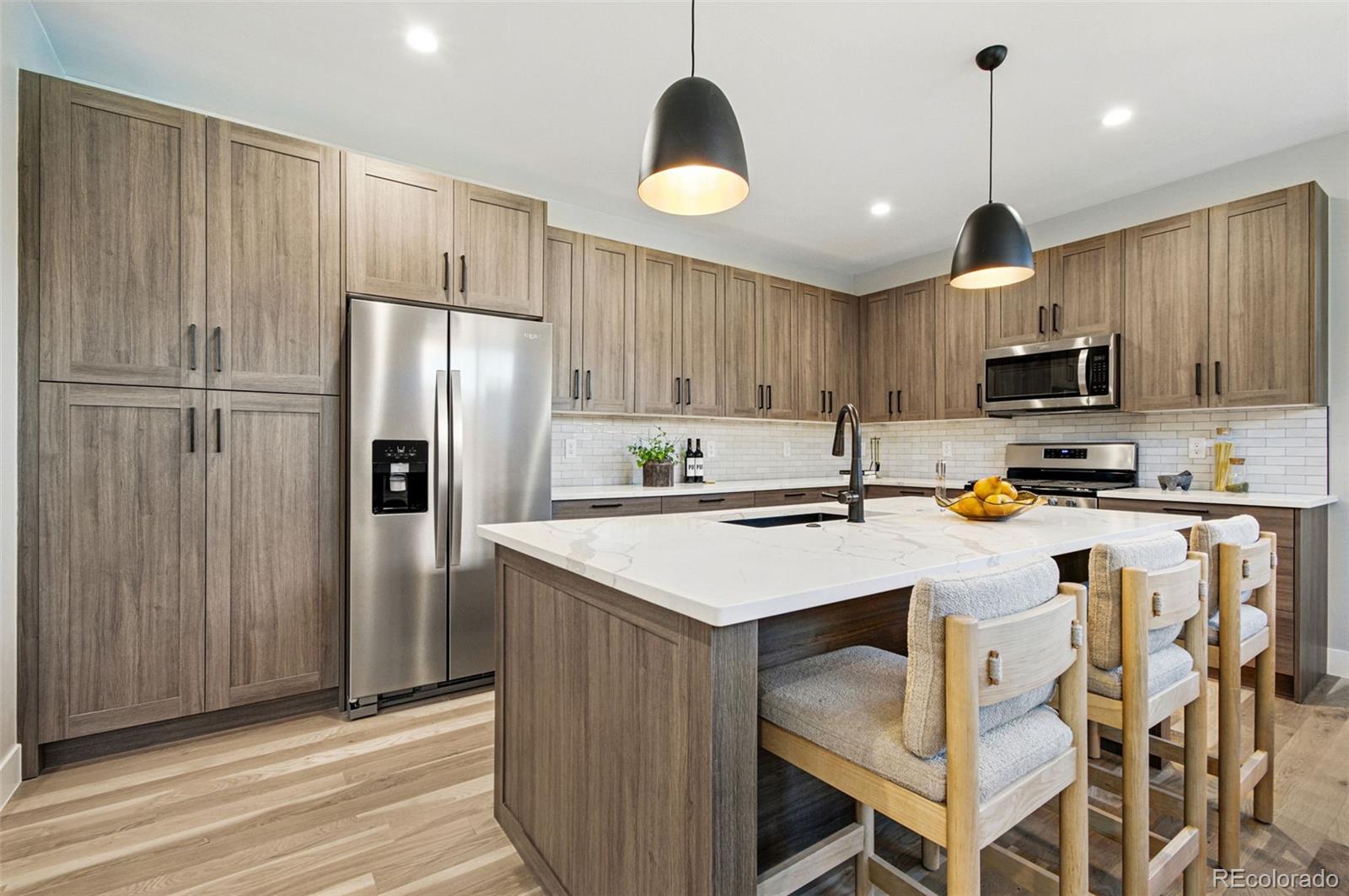 4121 Tejon Street Denver, CO 80211 - Photo 12 of 38 a kitchen with kitchen island a refrigerator stove and microwave
